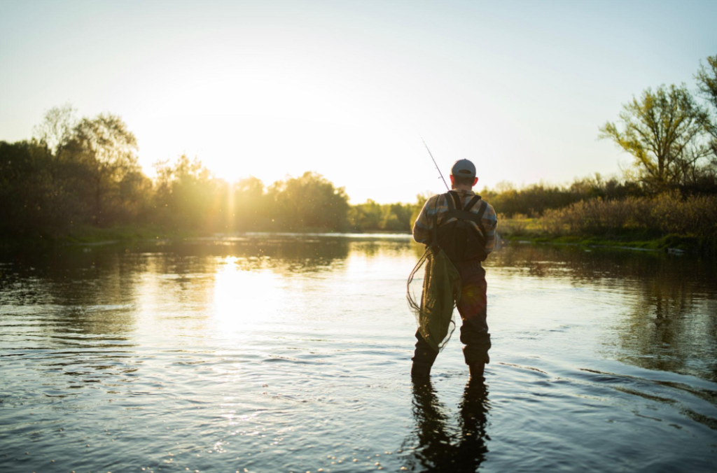 angler casting fly fishing reel setup in river
