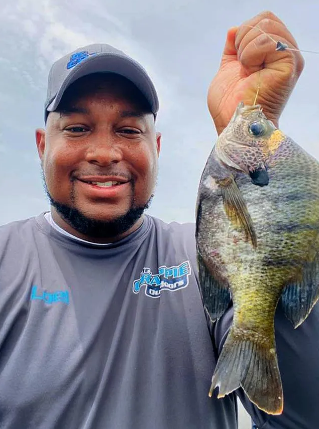 angler holding a freshly caught bluegill fish